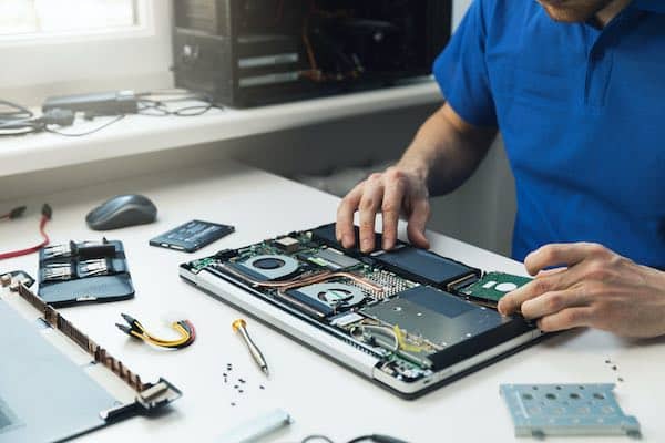 Man Installing New Hard Disk Drive in Laptop for Computer Repair